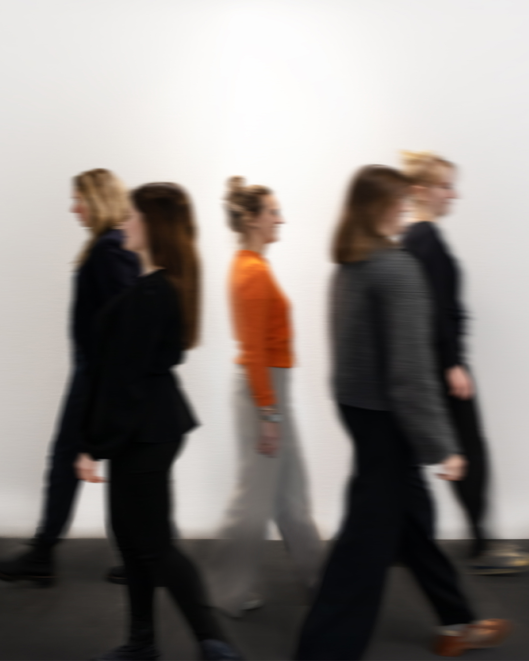 Das Team von MOOG MARKEN läuft von rechts nach links vor einem neutralen Hintergrund umher. Eine Bewegungsunschärfe spiegelt die Dynamik des Teams wider.
